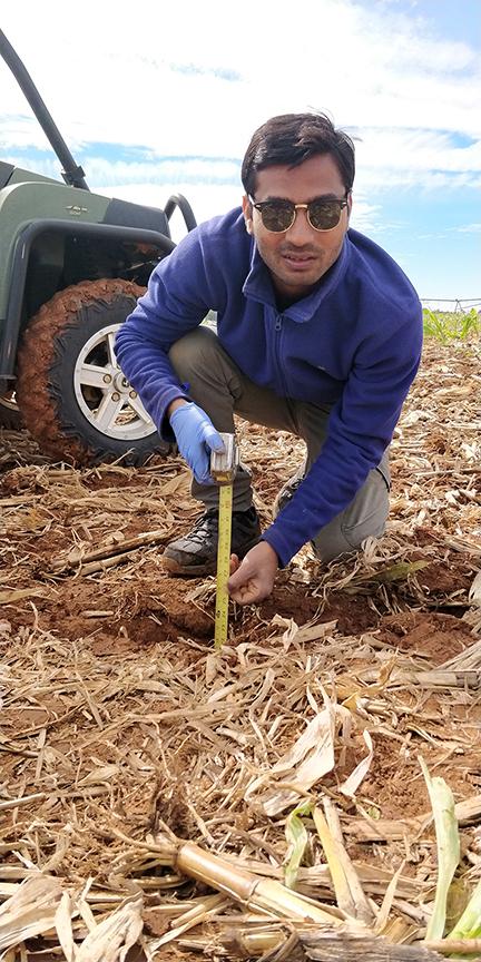 H. Kumar installing a soil sensor