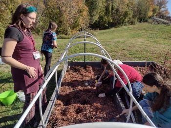 Gardening Club Youth and Volunteer working in gardening beds