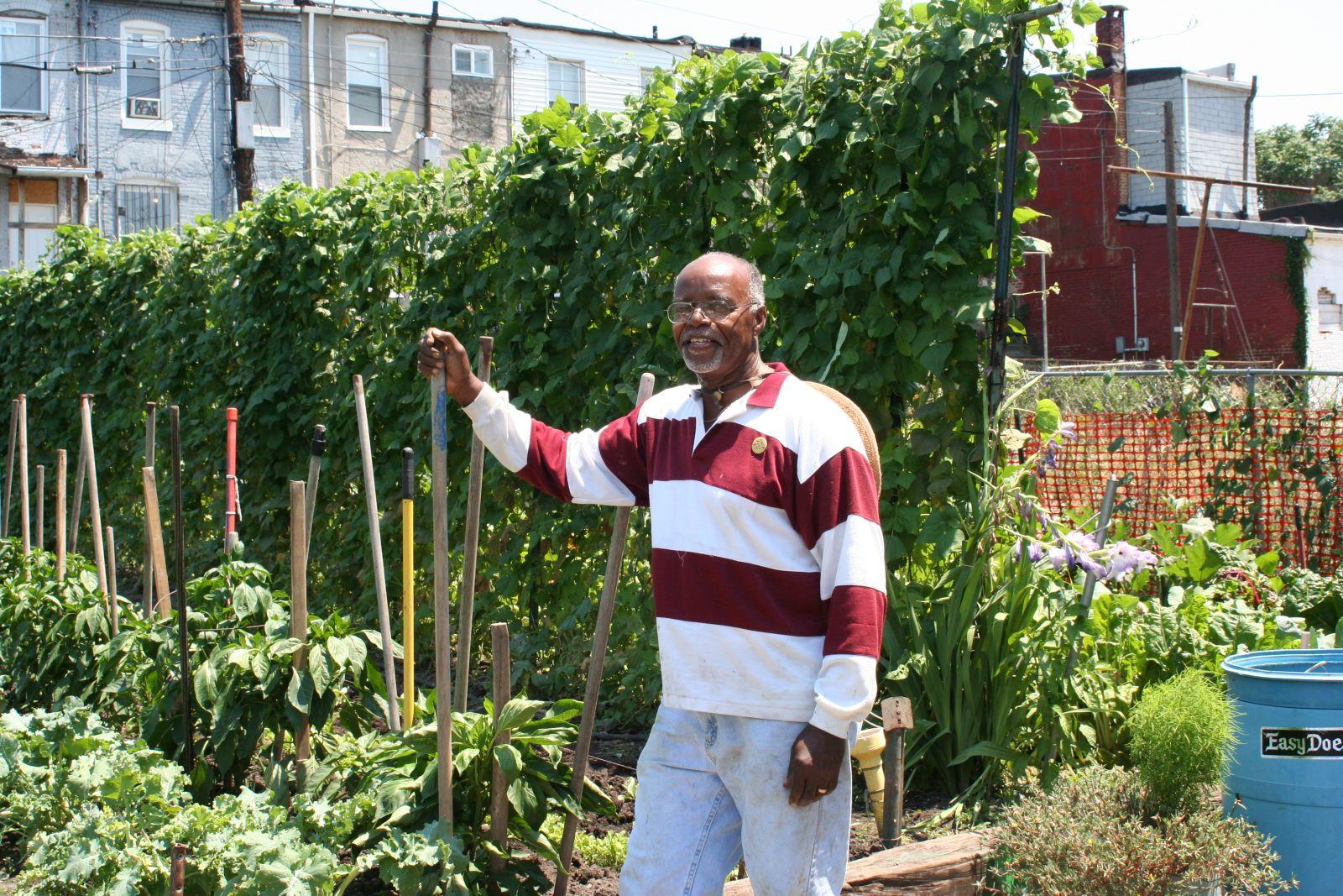a man standing by his vegetable garden in Baltimore