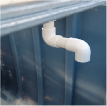 Setup of PVC pipe with three elbows positioned underneath the grow bed.