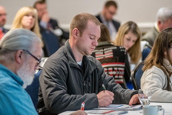 Participants at Ag Law conference jotting down notes during a presentation