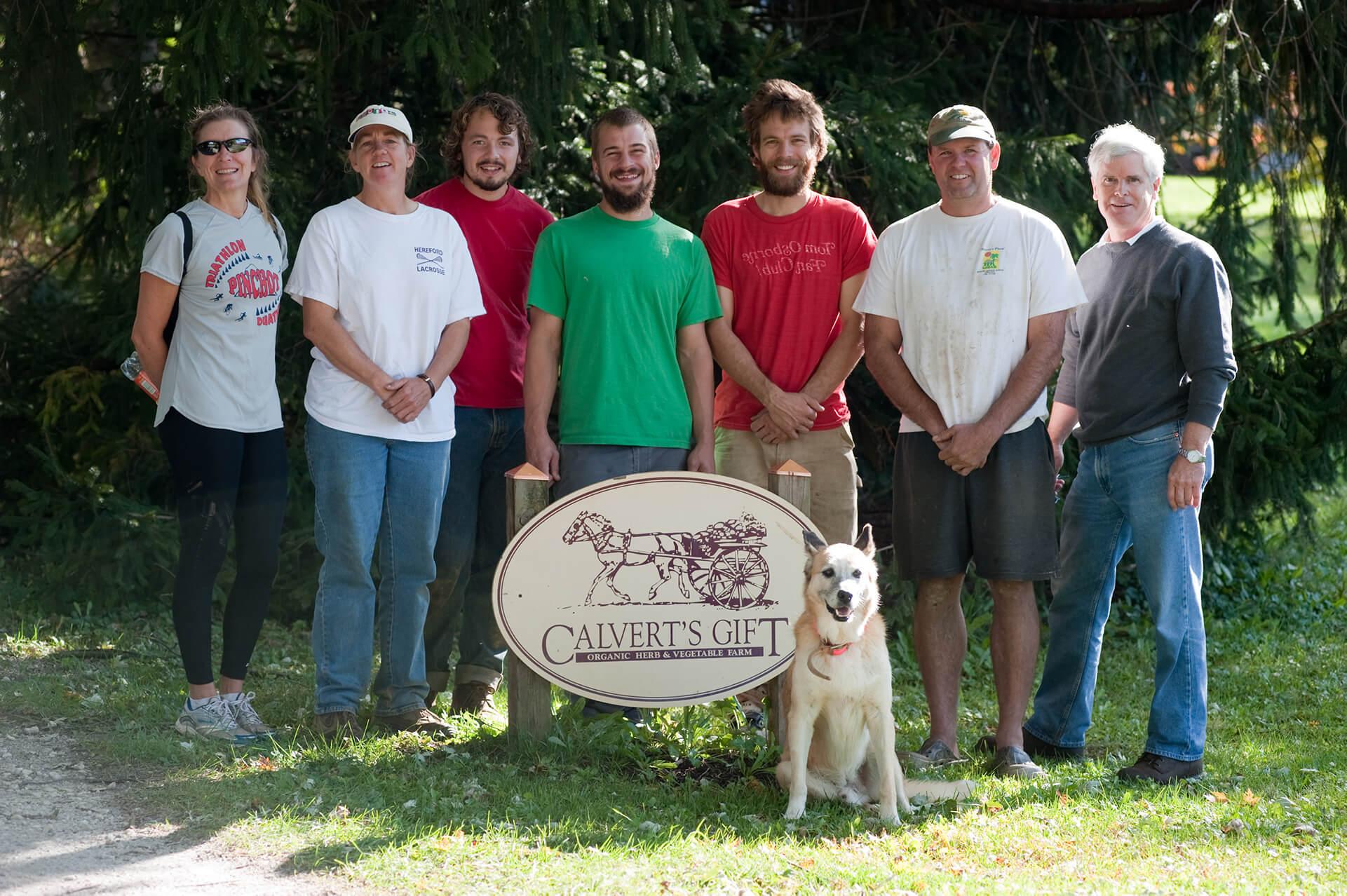 Group standing behind Calvert's Gift Organic herb and vegetable farm sign outside