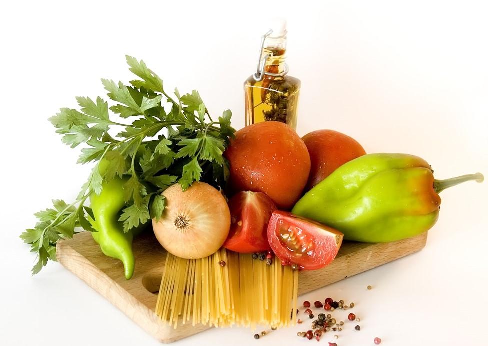 A bowl of healthy fruit, vegetables, and olive oil