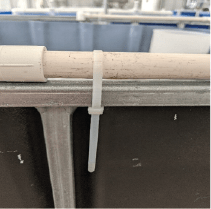 Zip tie attached to PVC pipe and frame.